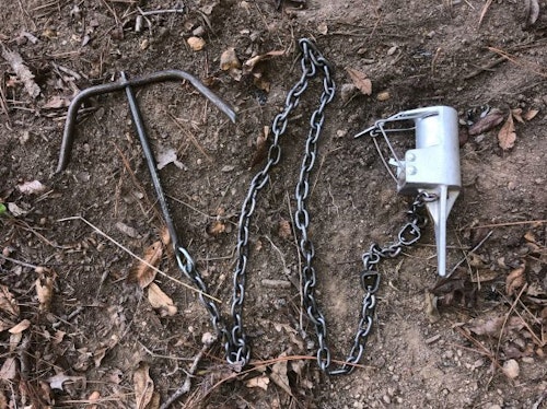 When selling traps, also make sure to carry the needed accessories, such as this chain and drag setup on this Feather-Lite dog-proof raccoon trap. Other items used to secure this style trap would be an earth anchor, re-bar stake or cable connected to a tree or pole.